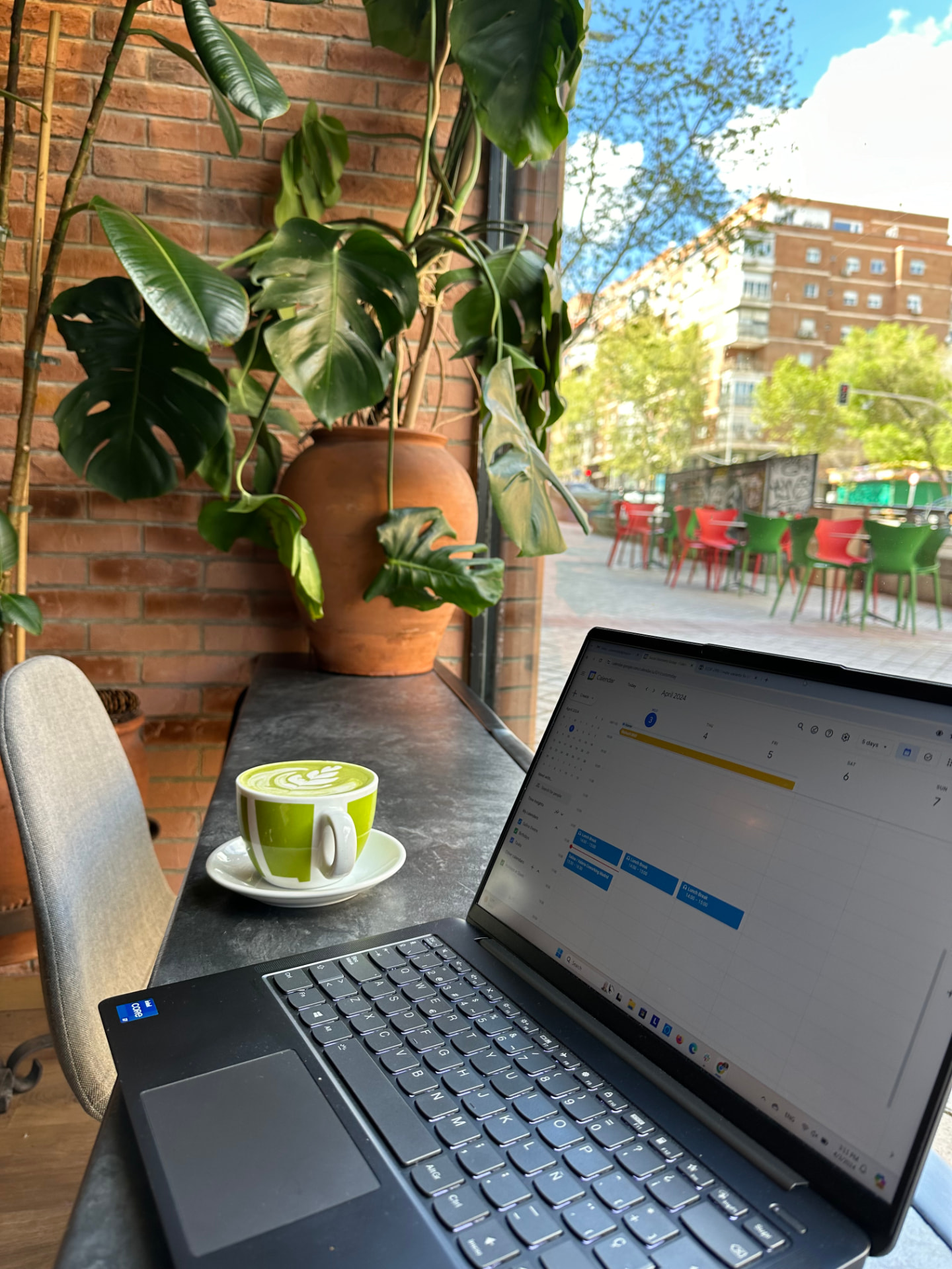Laptop and matcha at a sunny café terrace